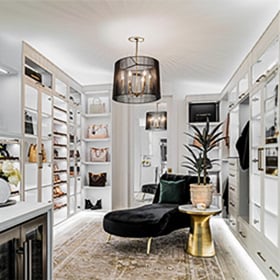Incorporate LED lighting to elevate your custom closet or other rooms in the home Refreshed walk in closet designed with custom LED lighting, open shelving, custom cabinets and drawers in a white wood grain finish by California Closets