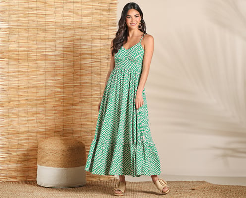 Woman is wearing a green and white patterned maxi dress.