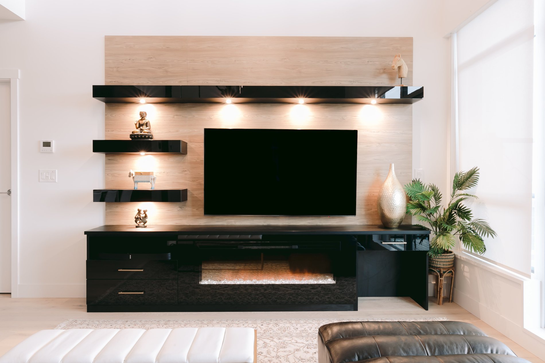 Sleek glossy media centre Full view of black media centre with wood tone backpanel