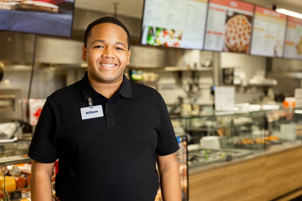employee standing in front of the deli section