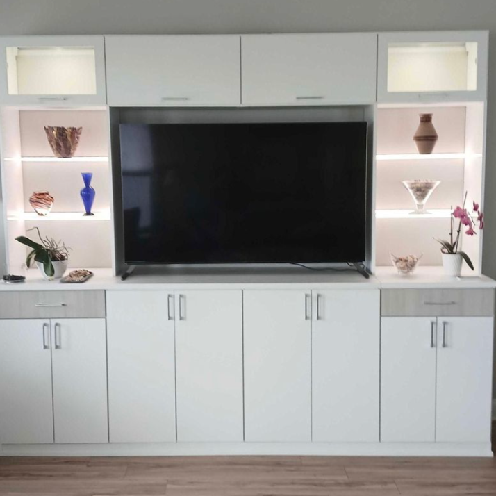 Built-in white custom billboards White cabinets and lit shelving for a living room or bedroom wall.