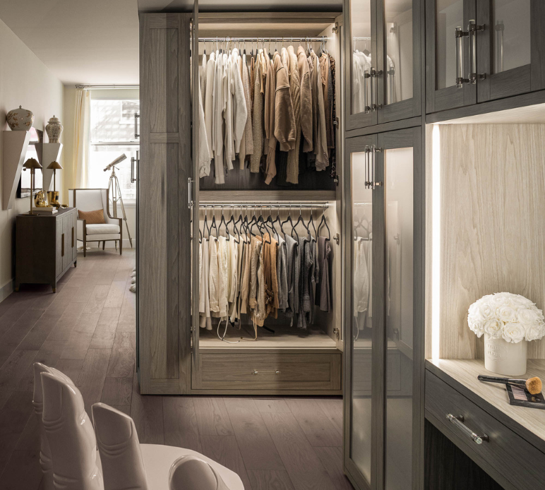 Luxurious Wardrobe luxury gray wardrobe walkin closet with color coordinated clothing, double hanging with doors open, doors have frosted glass, LED lighting, vanity and crystal hardware Manhattan New York