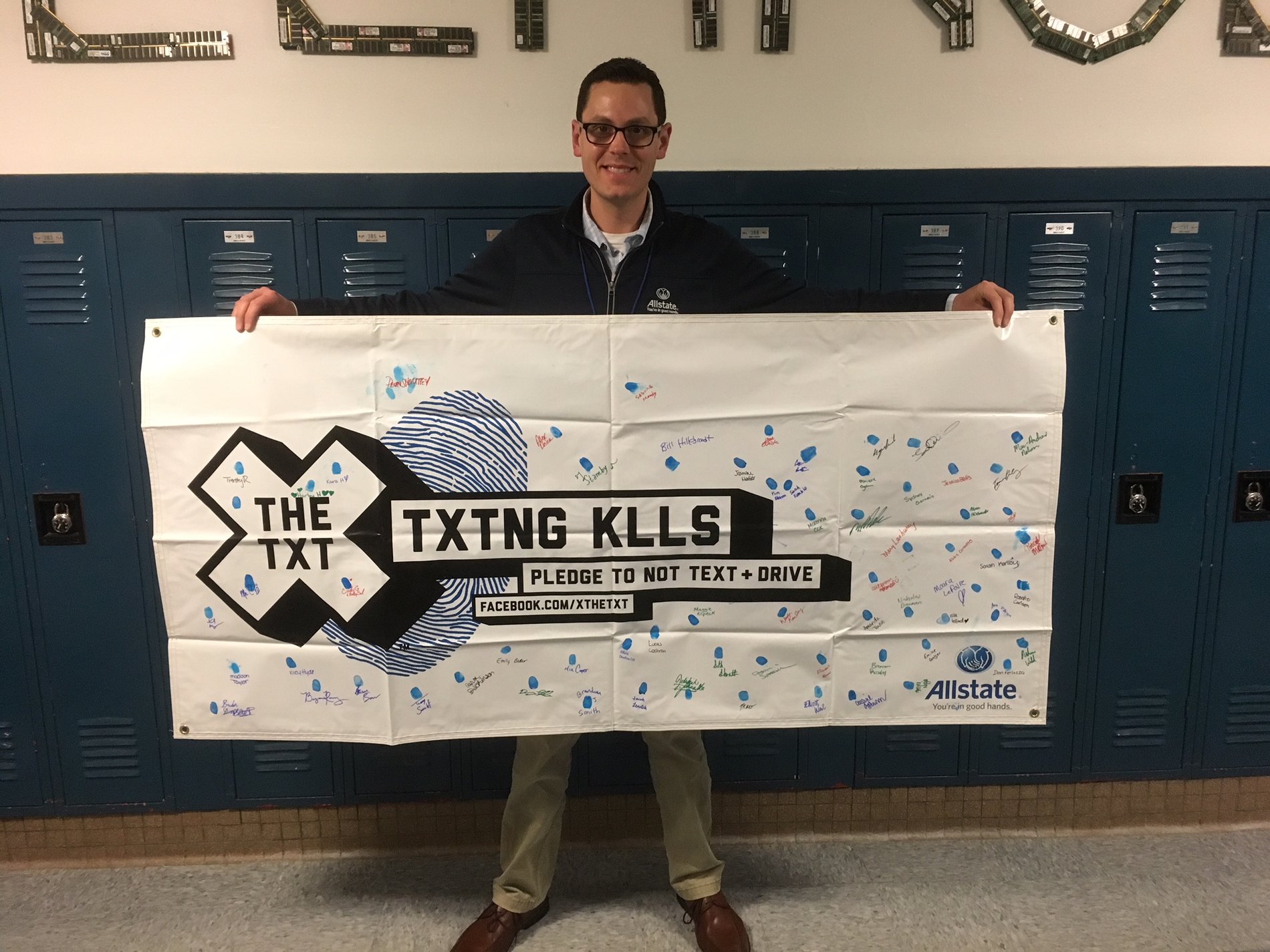 Allstate agent Don Ferlazzo displaying the X the Txt pledge banner. This event was held at the South Glen Falls Central School