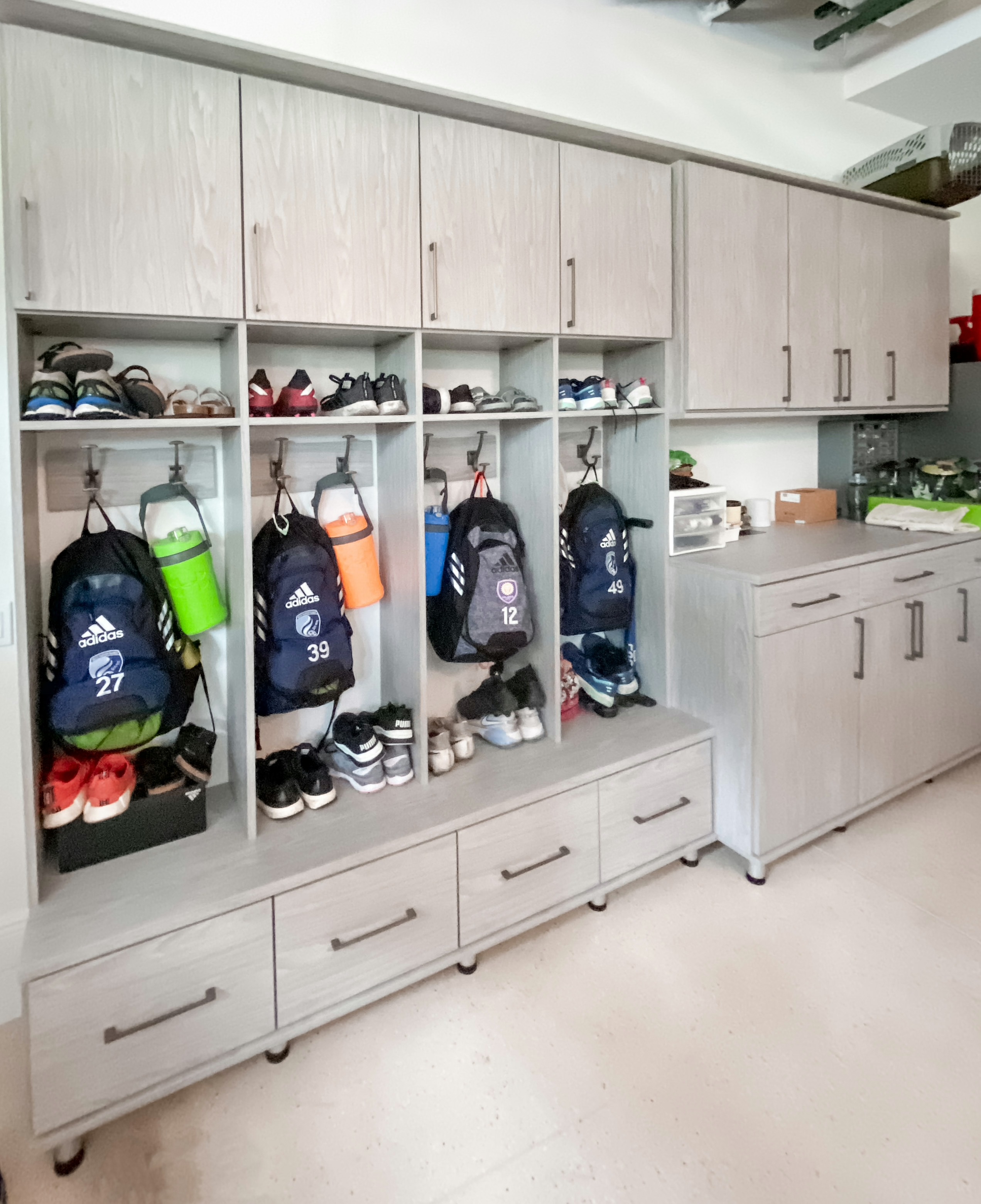 Custom Garage storage Modern grey garage workspace storage with custom storage and kids  lockers by California Closets Tampa Bay, Florida.