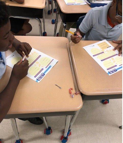 Two students working at their desks.