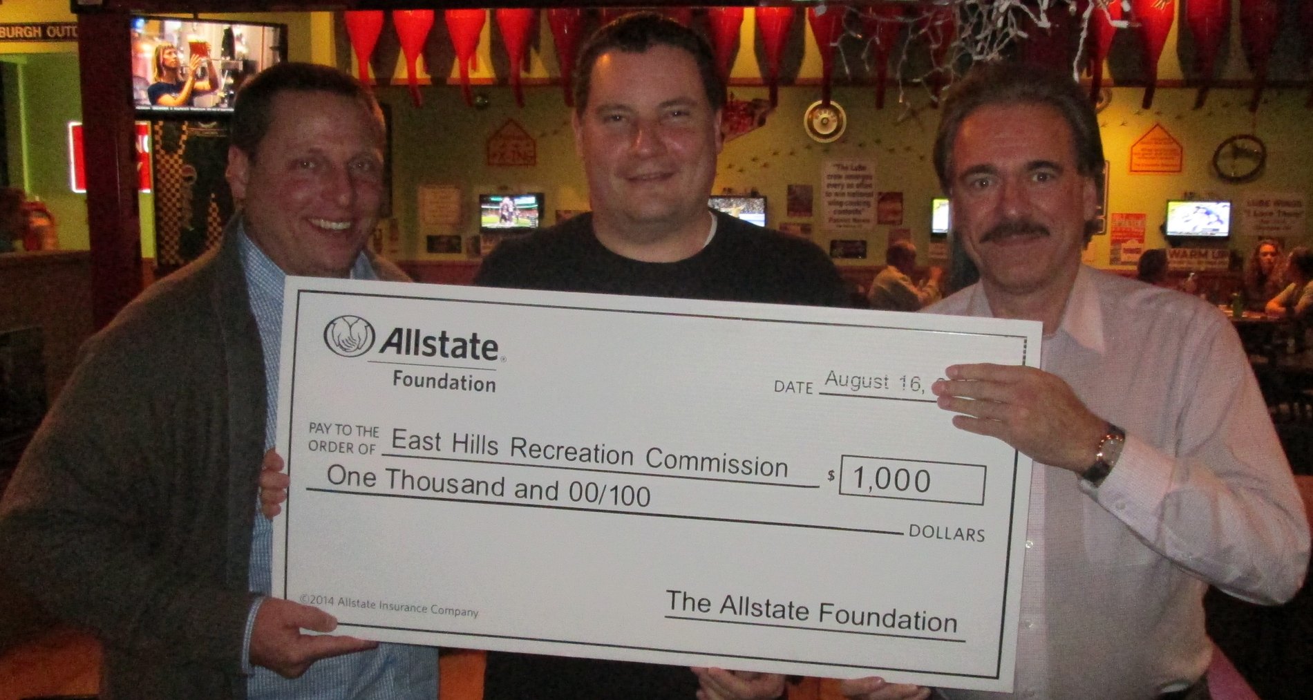 Duaine Detrick (Allstate agency owner) presents a $1,000 Allstate Foundation Hands in the Community Grant check as a volunteer to East Hills Recreation Commission.