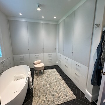 Wall-to-Wall Wardrobes That Maximize Space Custom wall-to-wall built-in wardrobes in Linen and Dove finishes with chrome hardware, designed for streamlined and elegant storage throughout the space.