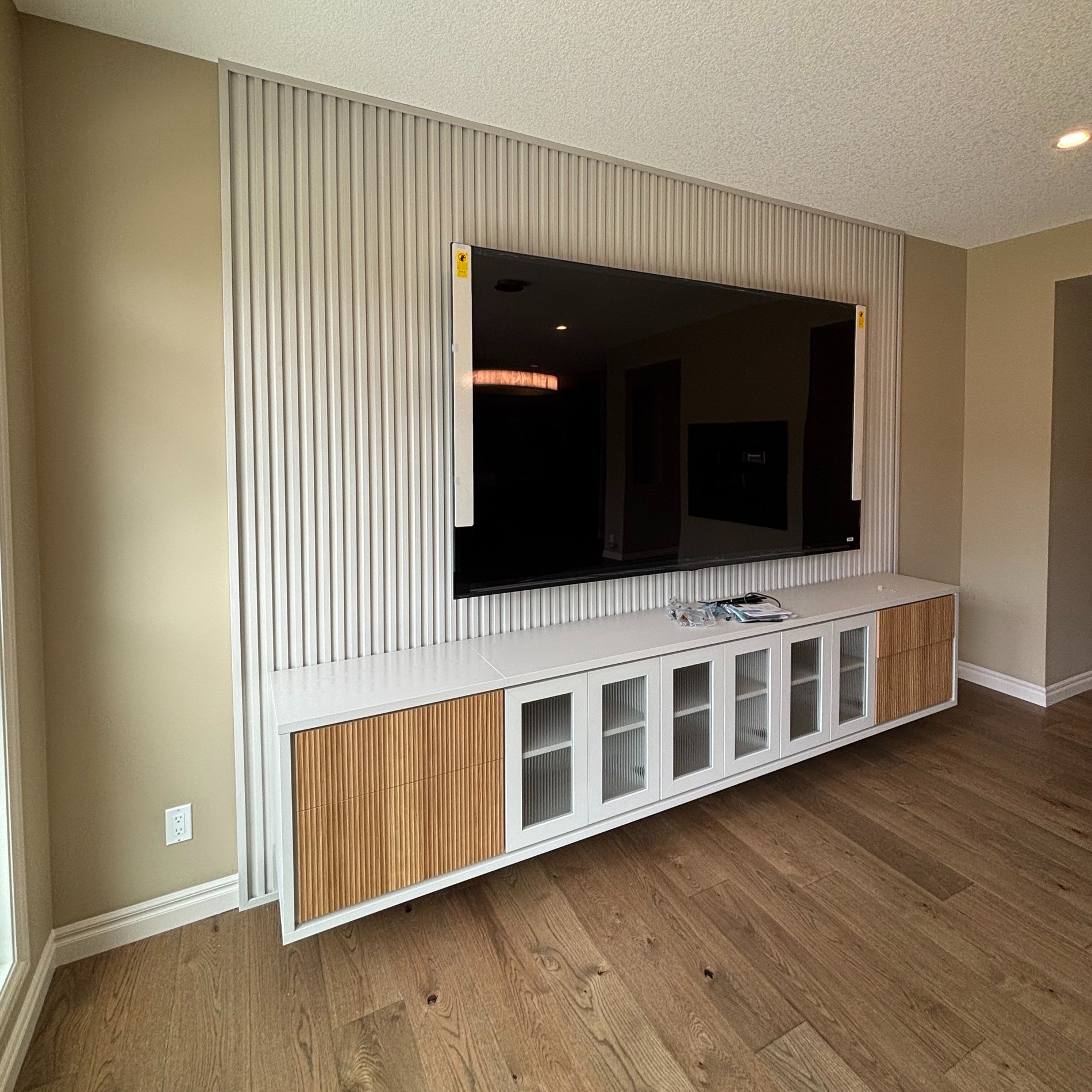 Upgraded Media Center Floating media unit with tambour backing, glass door fronts and contrasting wood doors.