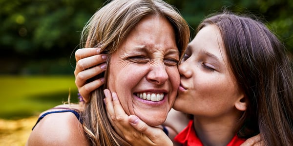 Woman kissing another woman's cheek