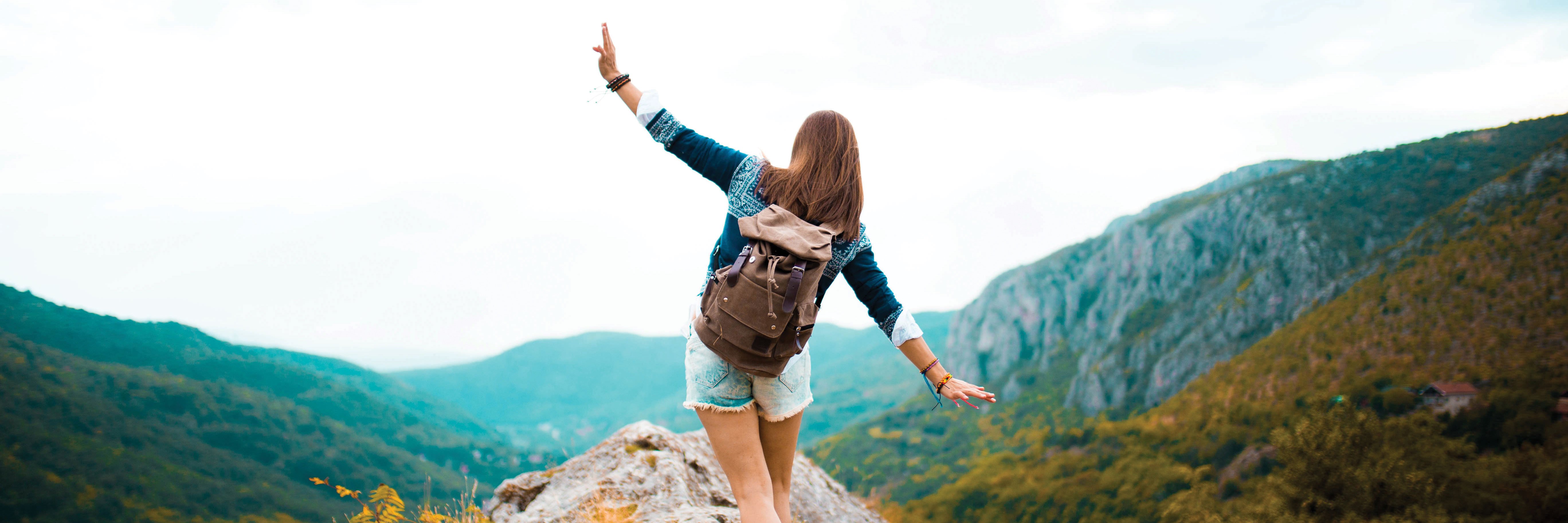 woman on the top of a rock in the mountains
