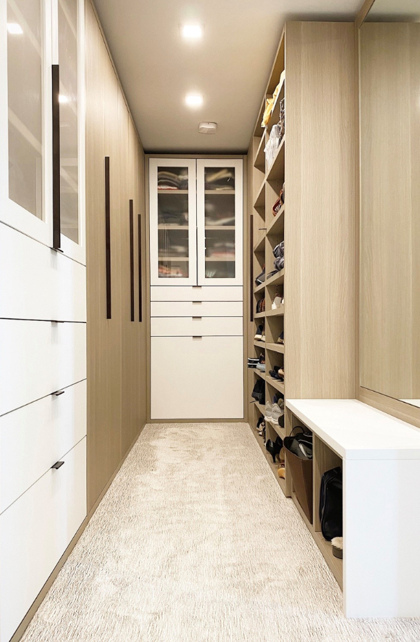 Two-toned Walk-in Closet white & natural wood walk-in closet with closed cabinetry, drawers, and custom bench Tribeca New York