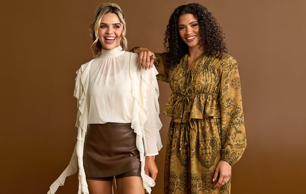 Two women are wearing neutral colored fall clothing.