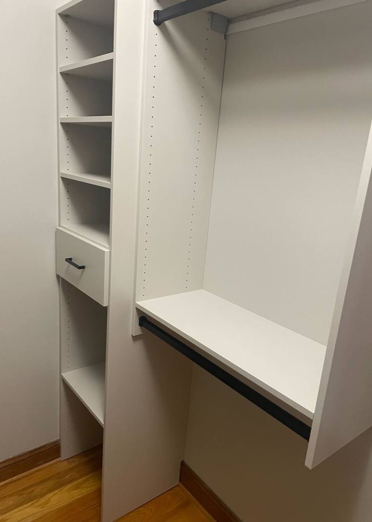 White Walk-In Closet with Hanging Dividers A white walk-in closet featuring hanging dividers and shelving.