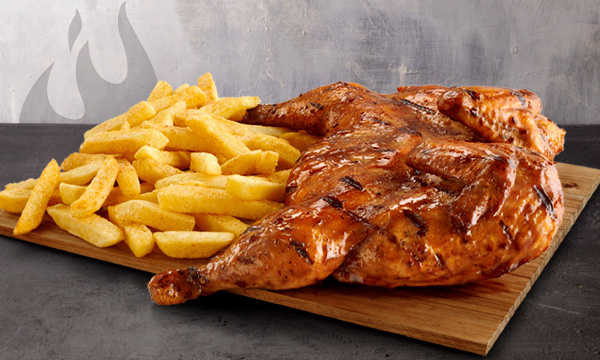 Flame-grilled full chicken with a portion of chips on a granite surface.