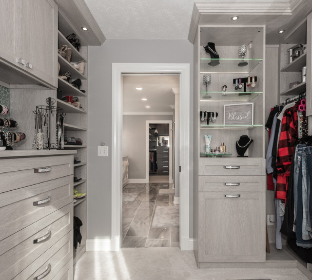 Custom Walk-In Closet Light grey walk-in closet with hanging space, shelving, drawers, and cabinets.