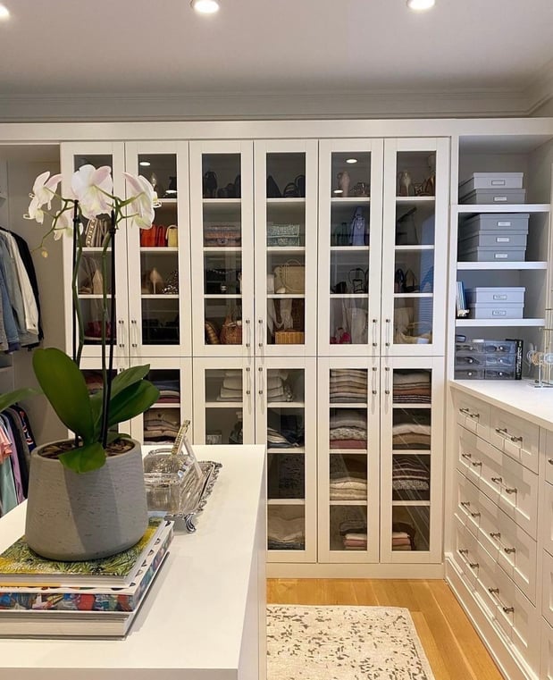 Bright walk-in closet with built-in dresser, cabinets, and shelving by California Closets Norwalk, Connecticut.