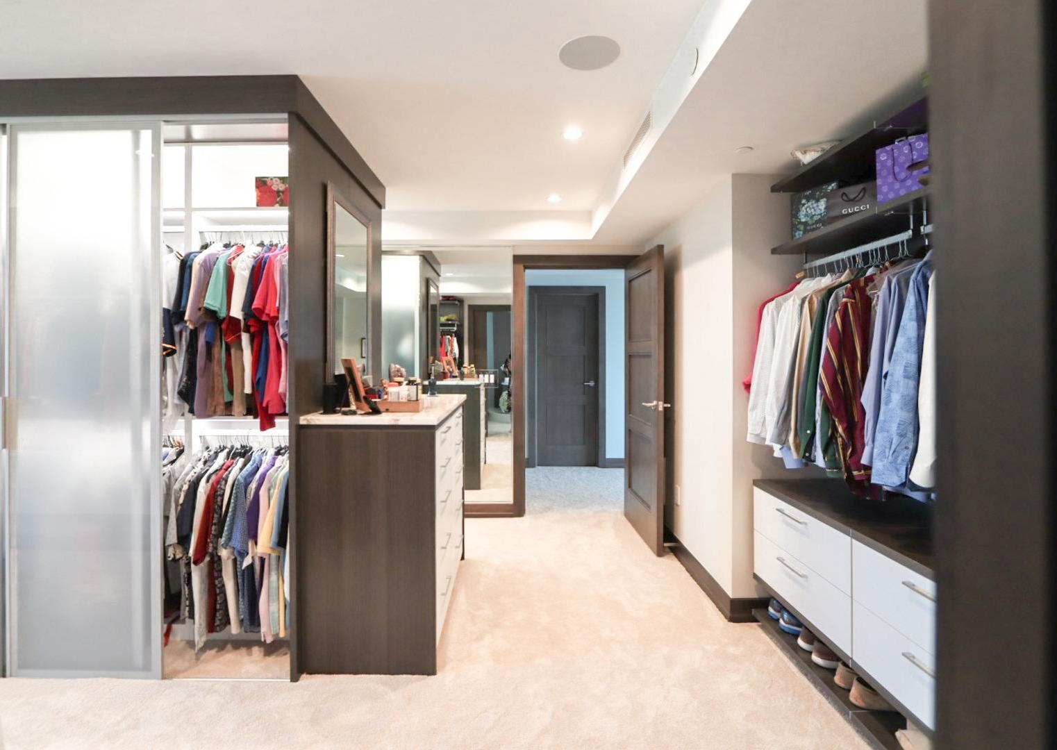 Modern his and her walk in Luxe two toned his and her walk in with sliding doors by California Closets Tampa Bay, Florida.
