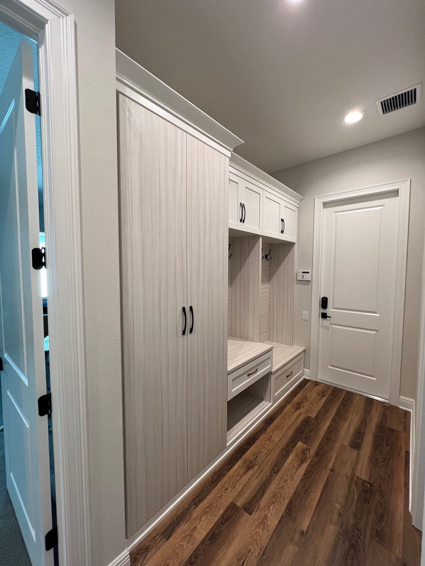 Stylish Mudroom in Tuscan Moon & Dove with Gold and Black Hardware This functional mudroom, featuring a mix of Tuscan Moon and Dove finishes with gold and black hardware.