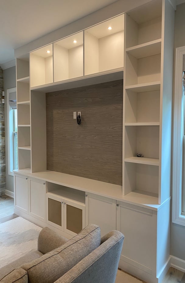 Custom Media Center with Integrated Storage and Display Shelving Custom media center and built-in entertainment center with custom cabinets, bookshelves, and living room storage. Integrated shelving and concealed storage create an organized, stylish solution for media equipment and decorative displays. Northville, Michigan