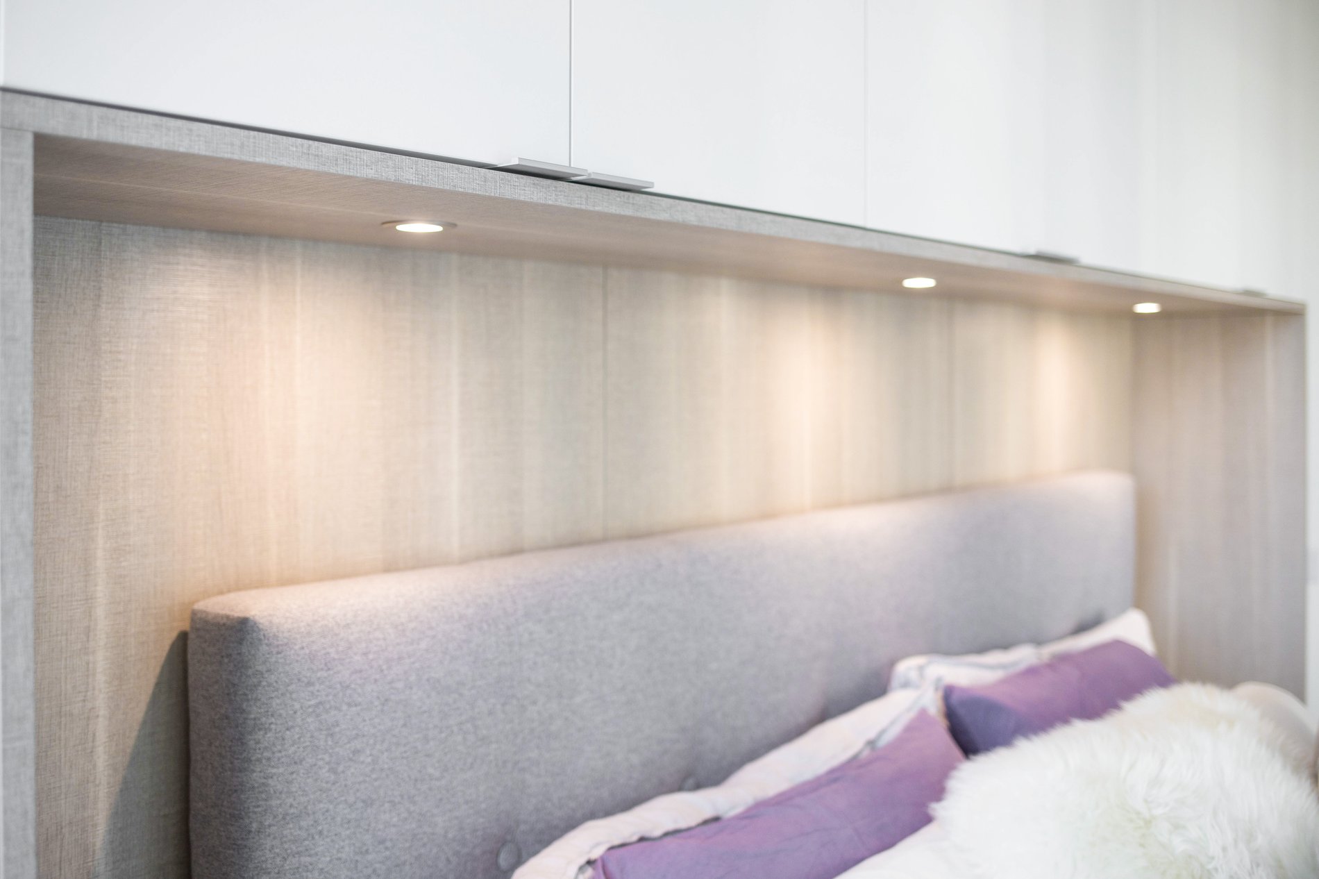 Above-bed storage with lighting Close up of under cabinet lighting above bed