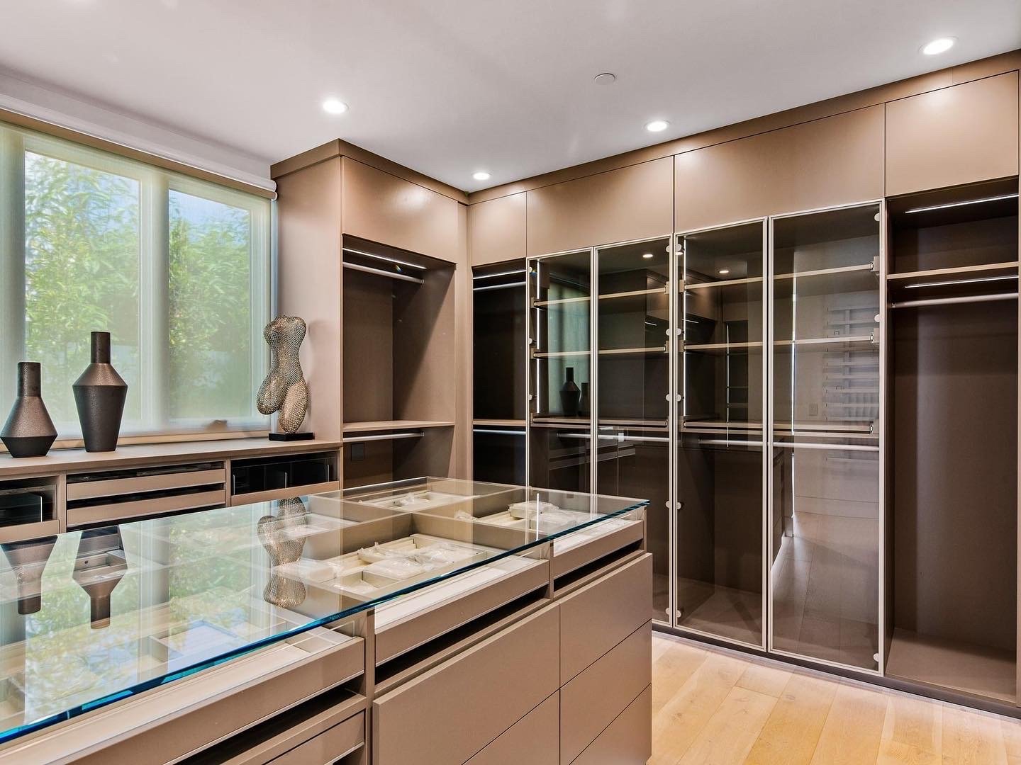 Luxe Custom Walk-In Closet Custom walk-in closet with glass doors and island by California Closets Toledo, Ohio. Abundance of closet organization and closets organizers.