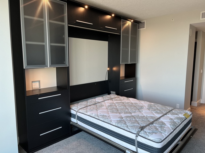 Luxe Murphy Bed Modern murphy bed design with black finishes, glass doors, and puck lighting.