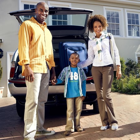 Family standing in front of a car.