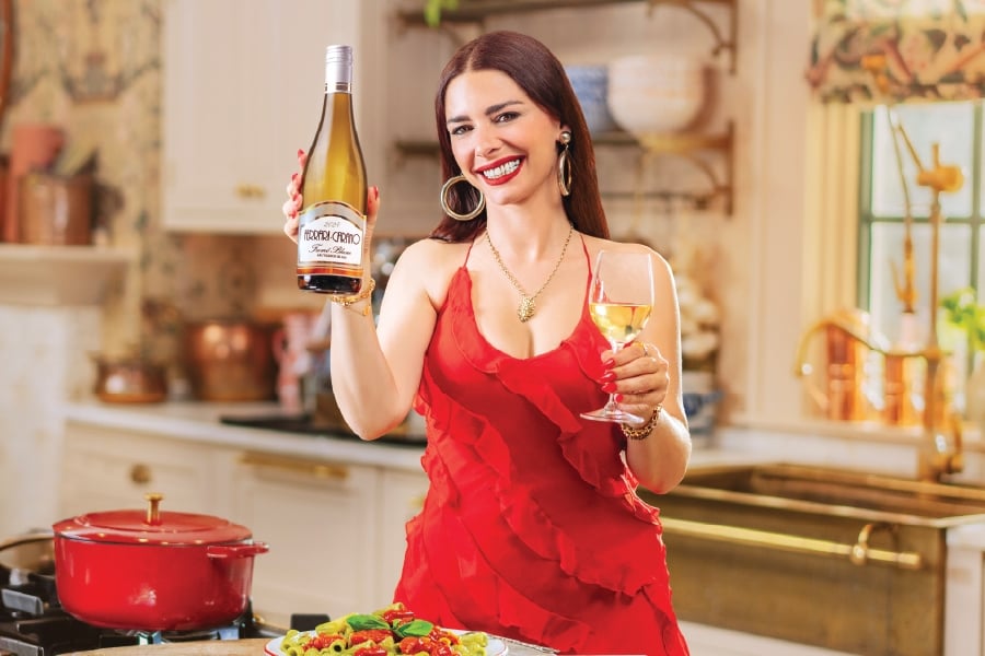 a woman holding a bottle of ferrari carano fume blanc