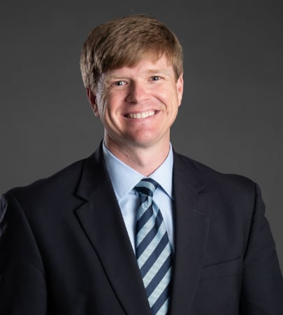 Male agent Jason Wallace profile photo in front of a grey background
