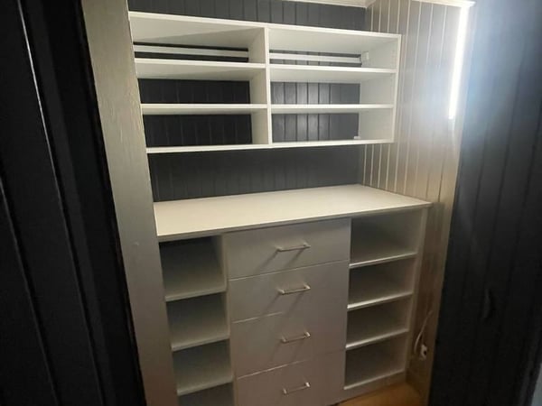 Modern closet design with side lighting, drawers and lots of shelving space from California Closets Wilmington, North Carolina.