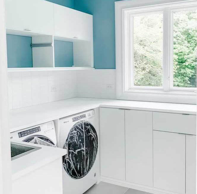 Laundry Room Oasis laundry room in white with washer and dryer and blue walls