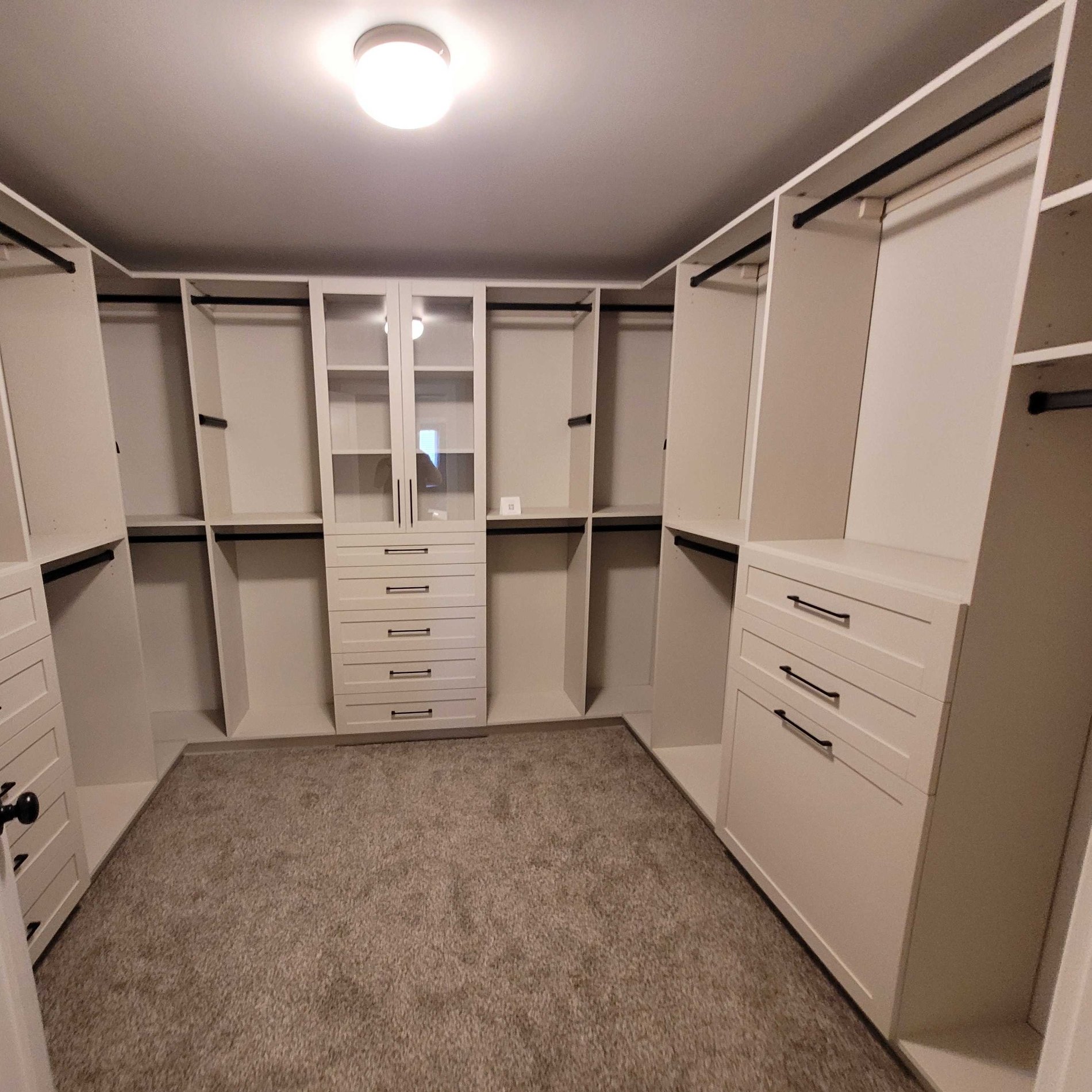 Custom Walk-In Closet Custom Walk in Closet with doors and drawers and a light