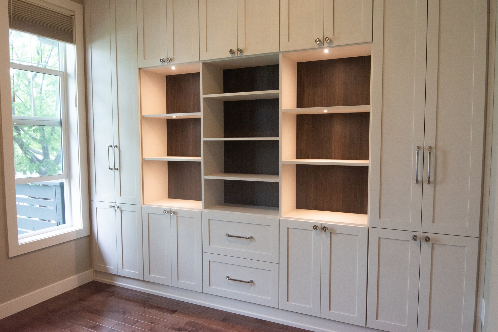 Traditional Home Office Design Home office designed for both parents and kids. Closed storage allows for hidden storage of office supplies as well as crafts and school supplies. Open shelving wight lighting and dark contrasting backing provides the perfect place to display special items.