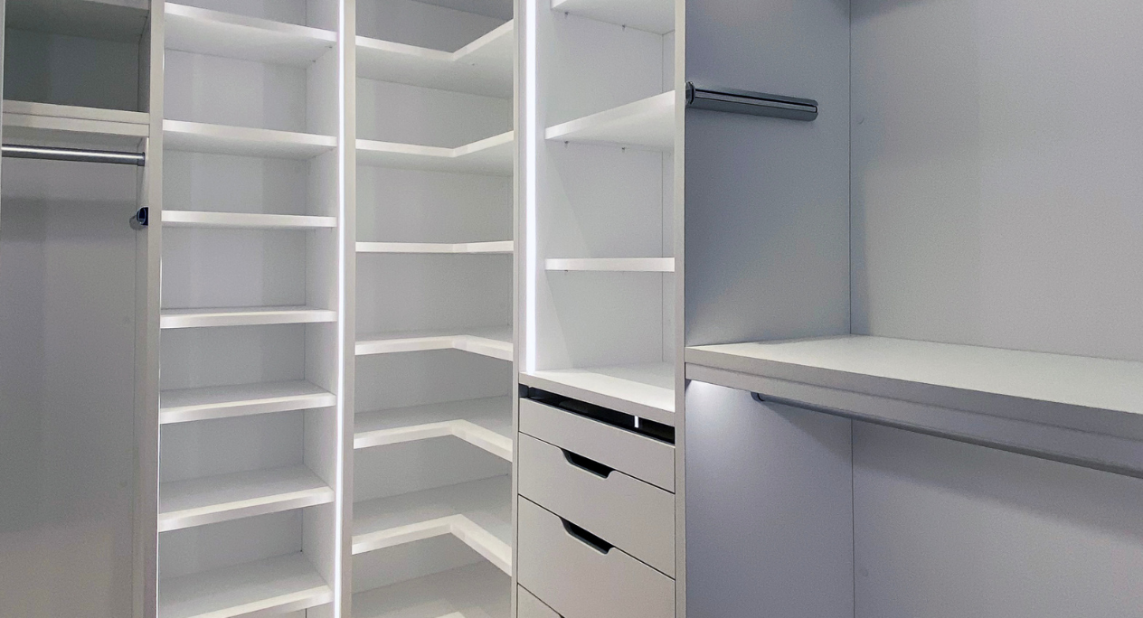 Crisp White Walk-in Closet white walk-in closet with LED lighting, shelving, hanging and modern drawers with modern hardware Tribeca New York