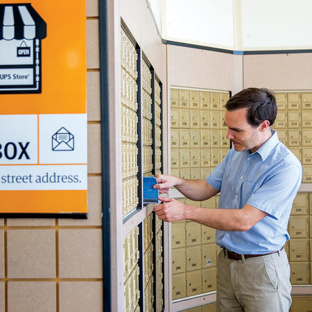 man getting mail from his private mailbox at the ups store