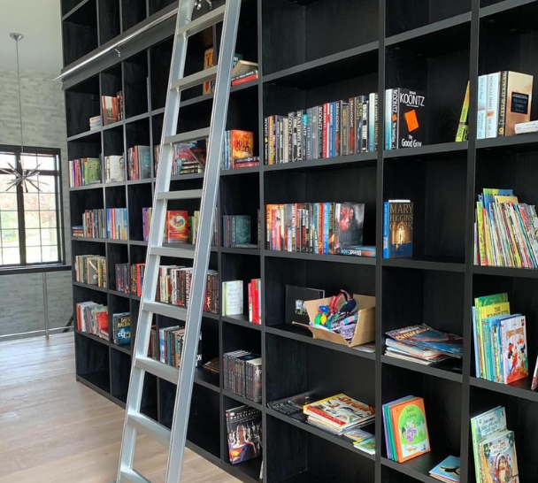 Wall Book Shelving With a Sliding Ladder Custom wall book shelving with a sliding ladder.