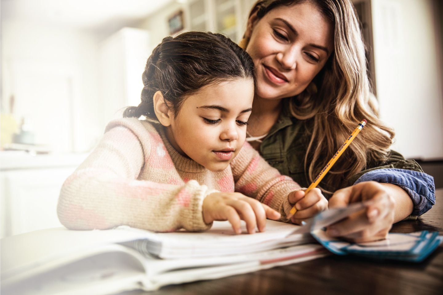 Women helping daughter with her homework.