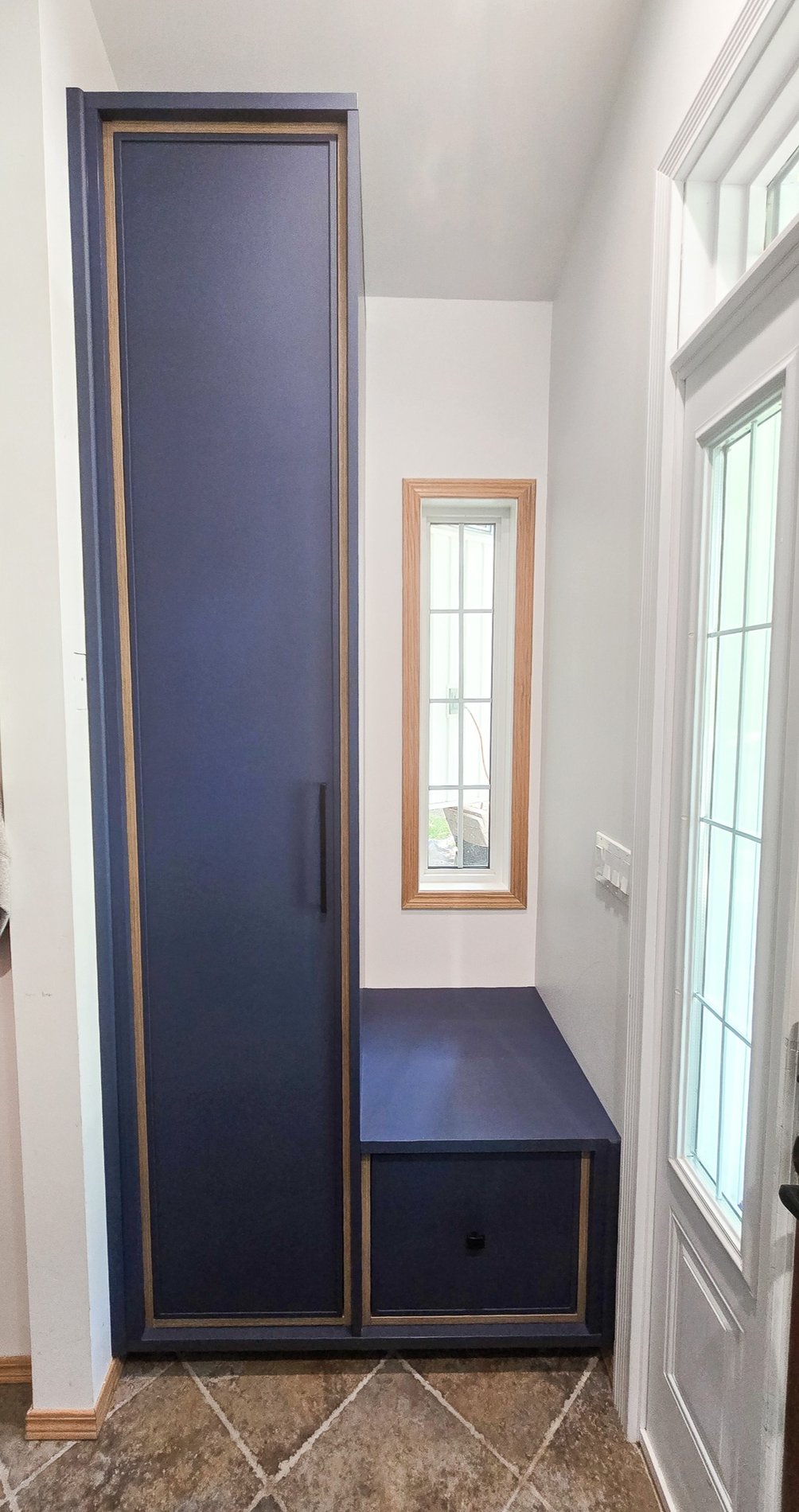 Small And Simple Entry Way Dark blue entryway system with long hanging, shoe storage, and a small bench to sit on.