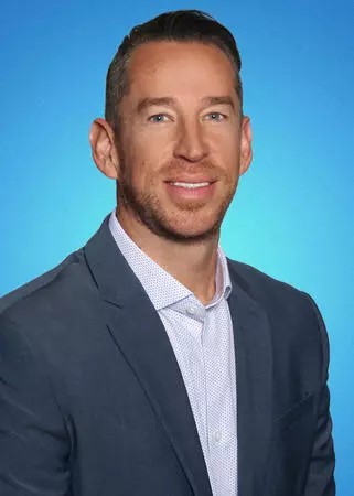 Male agent Nathan Giddings profile photo in front of a blue background