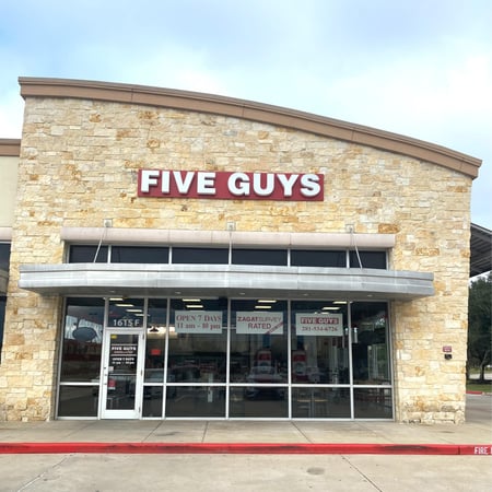 Exterior photograph of the Five Guys restaurant at 1615 North FM 646 in League City, Texas.