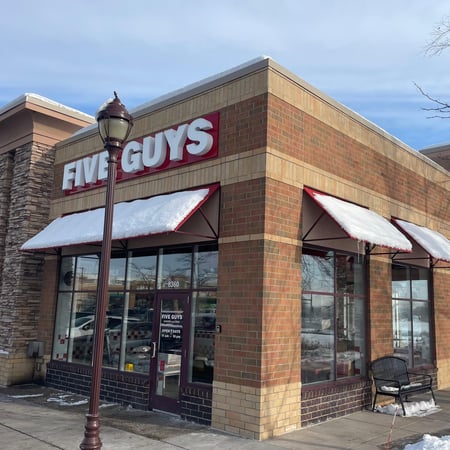 Exterior photograph of the Five Guys restaurant at 8360 Third Street North in Oakdale, Minnesota.