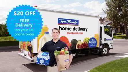Delivery man standing in front of Tom Thumb delivery truck holding groceries.