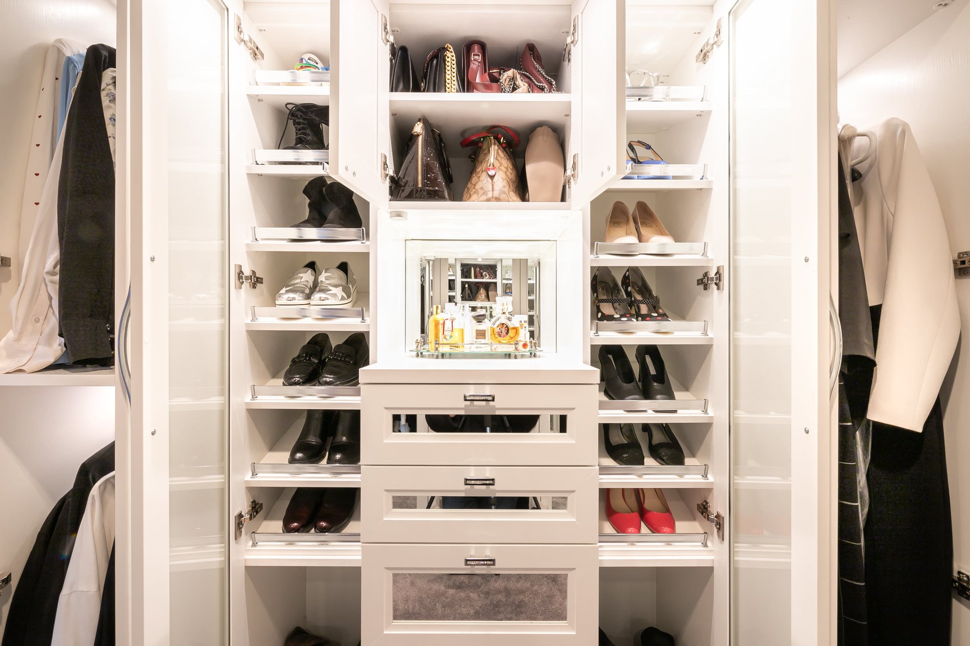 Pull-out shelves for shoes Pull out shelving for shoe storage in a white walk in closet