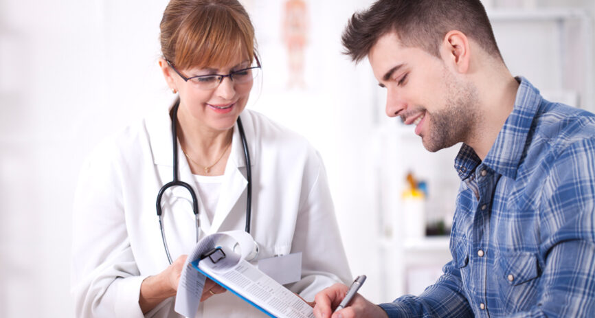 A female doctor helps a patient with paperwork.