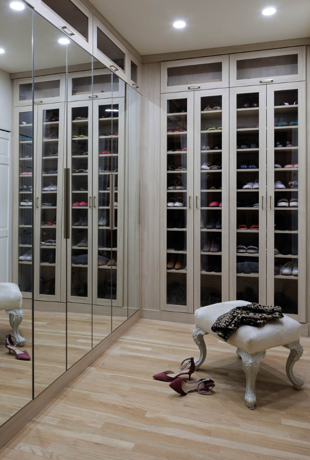 Central Park Luxury Walk-in Closet full room walkin closet floor to ceiling cabinetry with mirrored doors, glass transparent doors for shoe collection and footstool in the center
