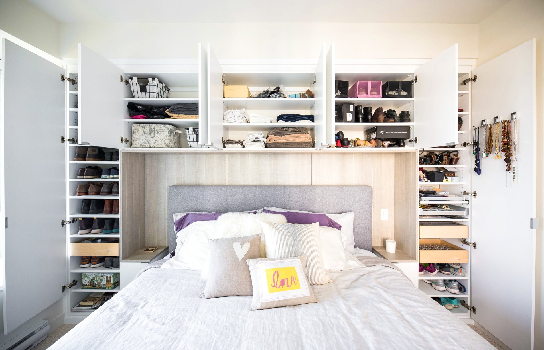 Storage surround in bedroom Built in storage above and on either side of a bedroom with space for a queen size bed