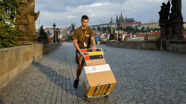 UPS courier pushing packages on a hand truck