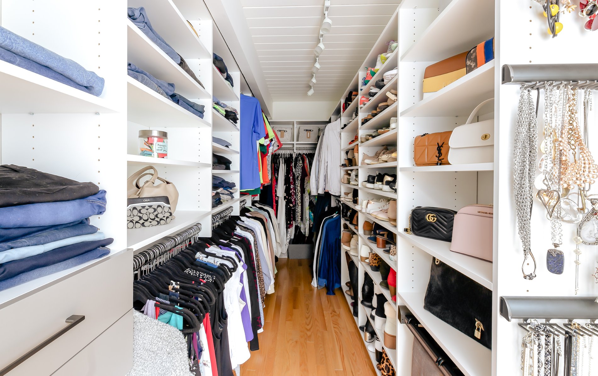Lengthy Walk-in Closet lengthy custom closet with lots of hanging and shelving by California Closets Vancouver, British Columbia.