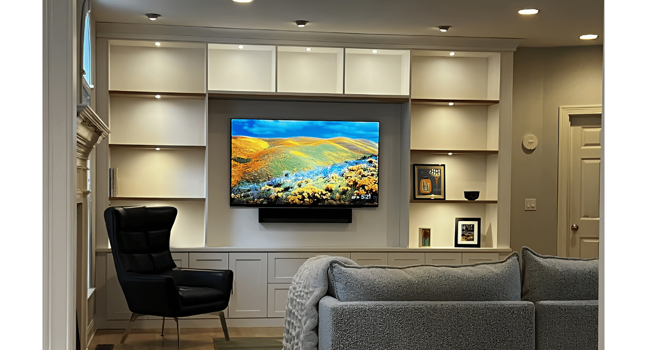 Stylish Custom Media Center Built-in media center with lighting above shelves and lower cabinetry.