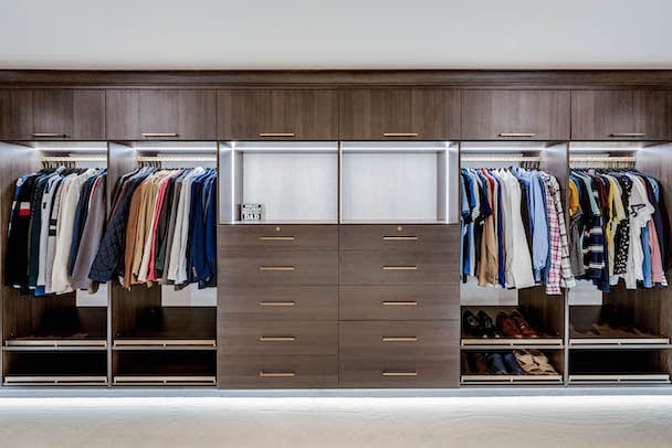 Luxury Walk-In for Him x Toll Brothers Custom walk-in for him with dark wood drawers and doors.